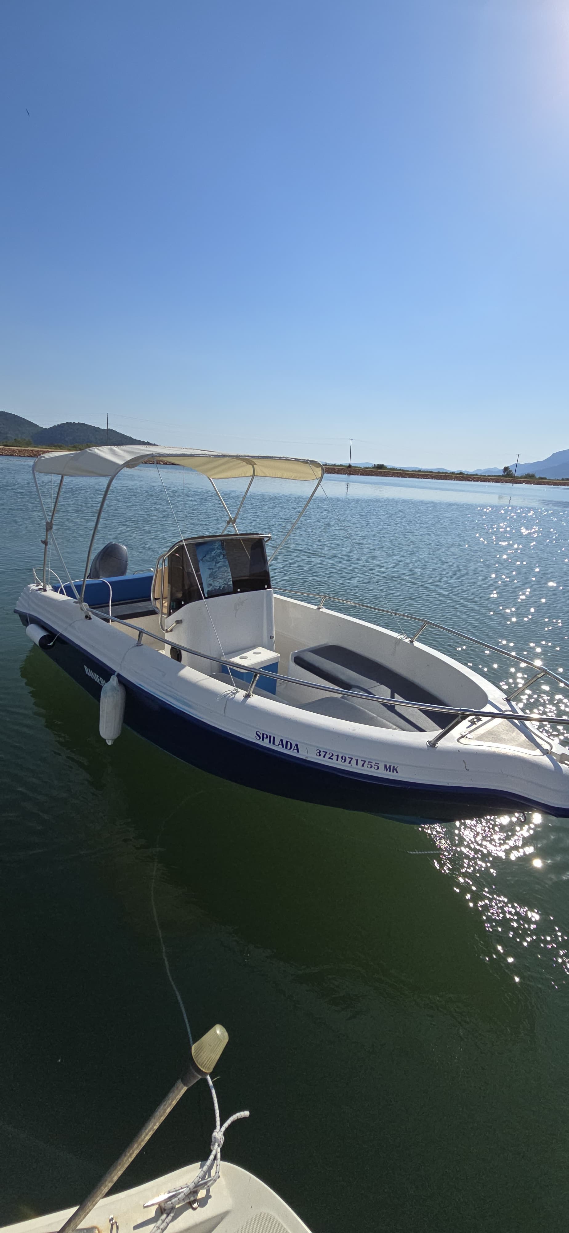 Front view of the Spilada 5.2m self-drive rental boat docked in calm waters in Butrint, requiring no boating license