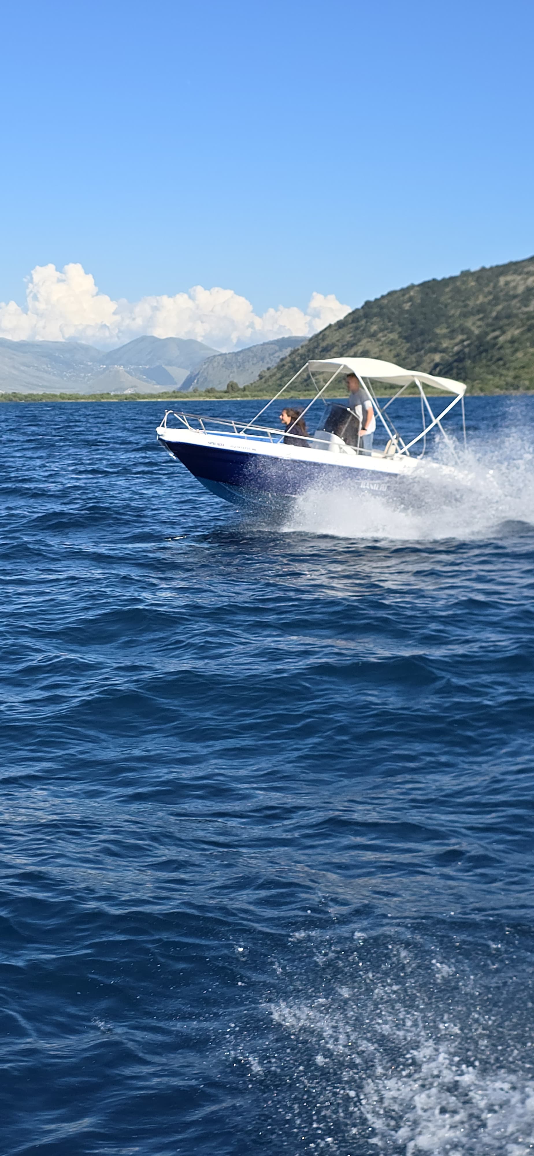 Tourists enjoying an easy, license-free boat ride on the Spilada 30HP across the beautiful blue waters of the Albanian Riviera