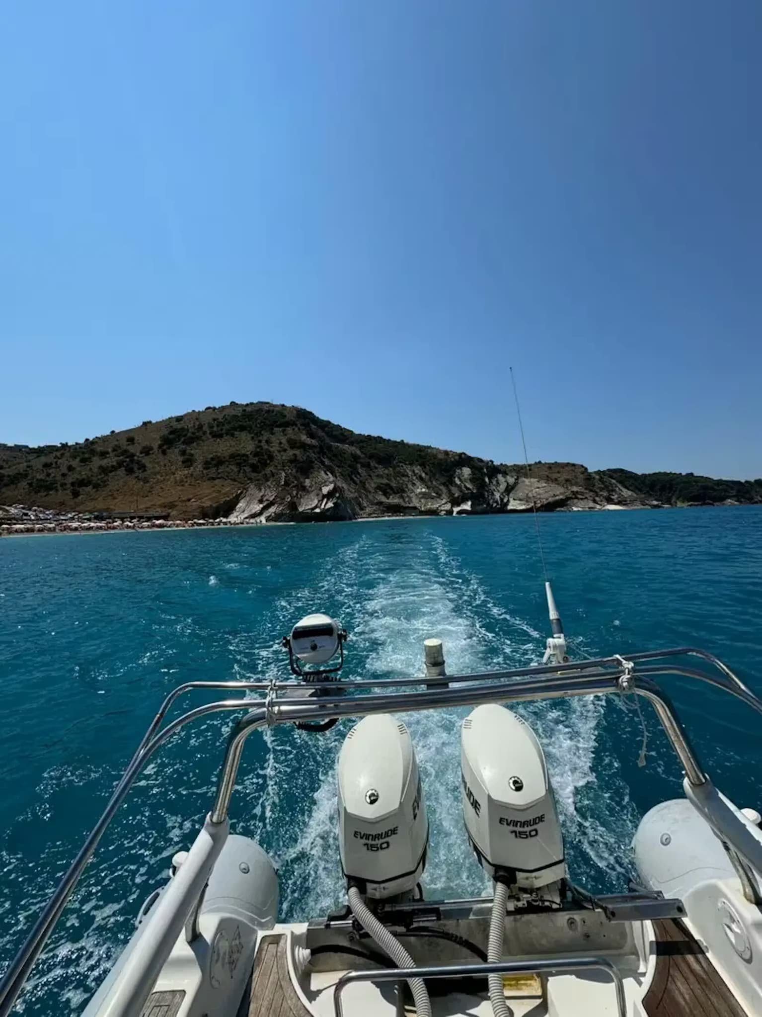 Looking back from the deck of our twin-engine RIB boat leaving a wake as we cruise along the scenic Ksamil coastline